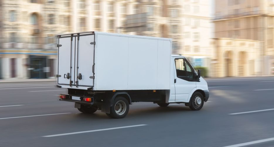 Truck is moving down the street in the city